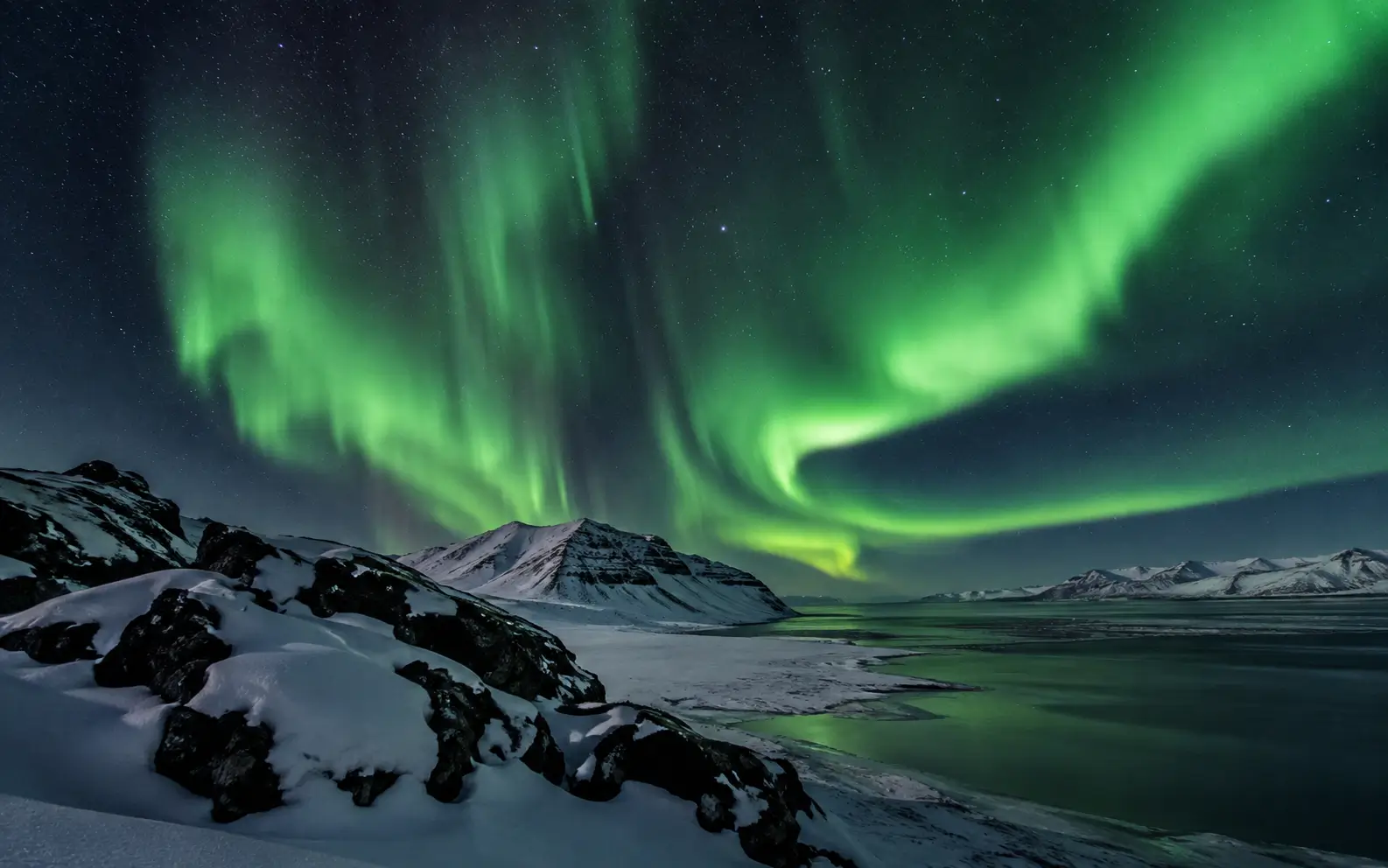 Northern Lights above a dark Icelandic winter landscape